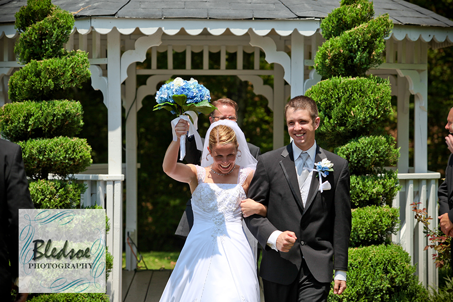 Bride cheers as she walks back down the aisle with her groom at Dara's Garden.