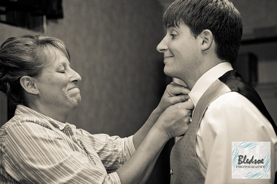Groom's mom straightening his tie. © Bledsoe Photography