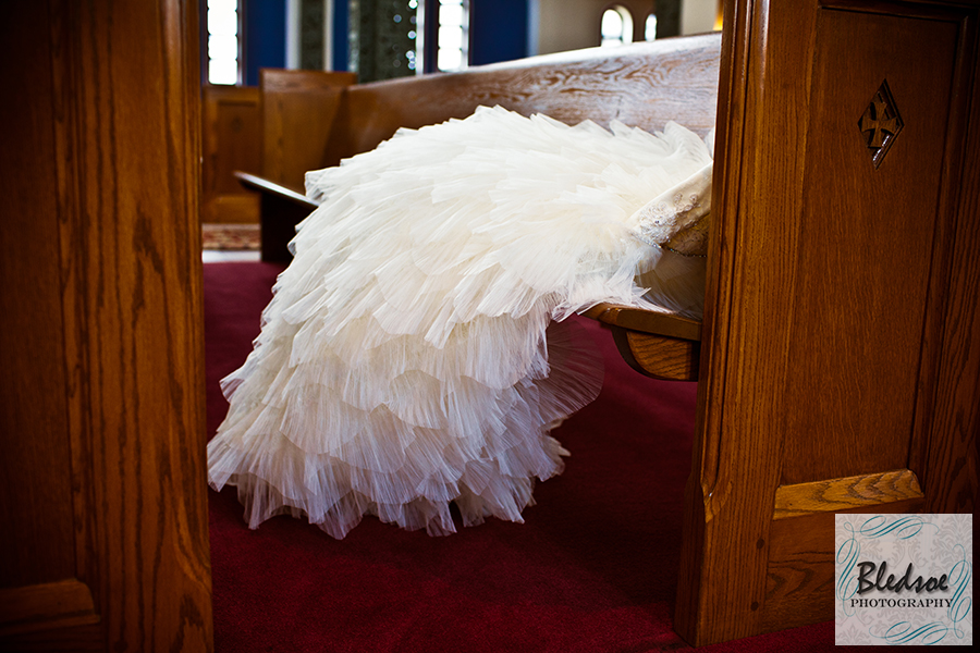 Wedding gown in a church pew.  Bledsoe Photography