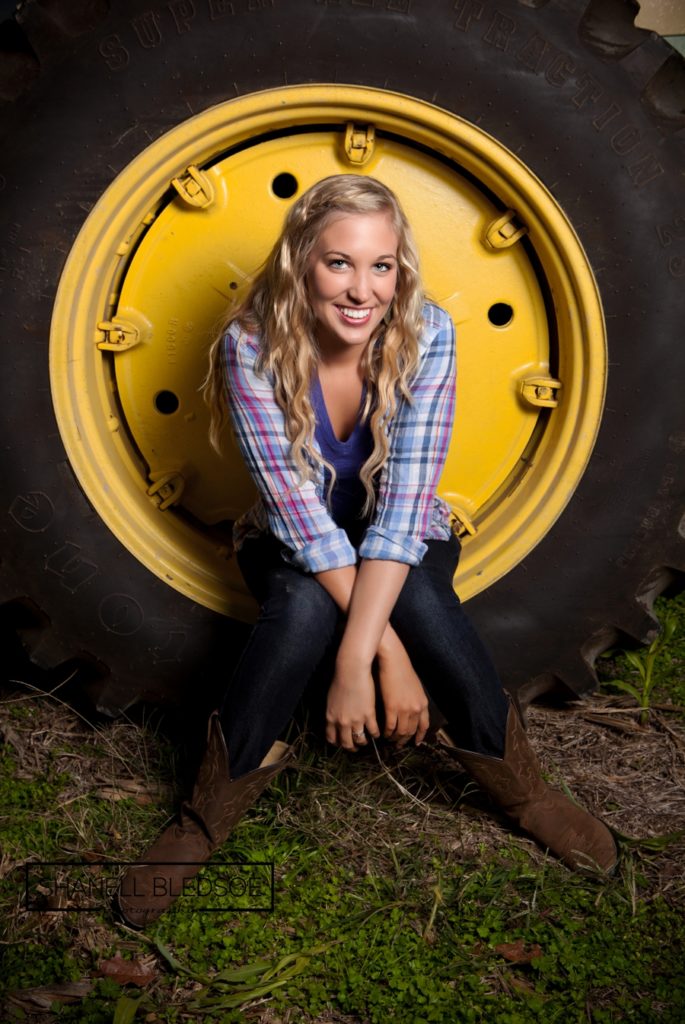 senior photo inside a tractor wheel