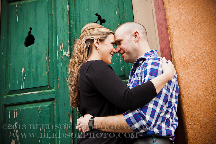Knoxville engagement photo session in the Old City, couple hugging in front of a green door © Bledsoe Photography