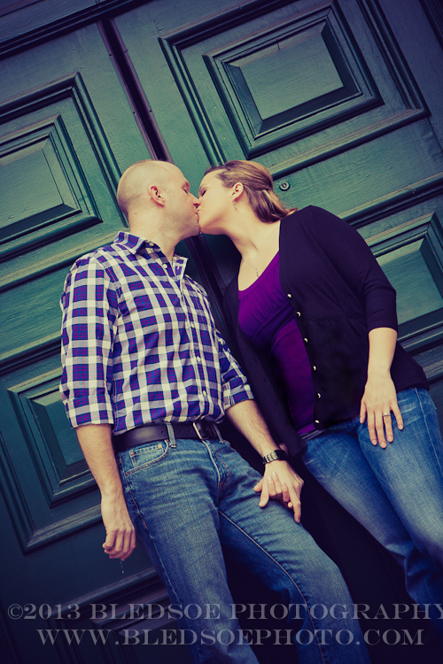 Knoxville engagement photo session in the Old City, couple kissing in front of a green door © Bledsoe Photography