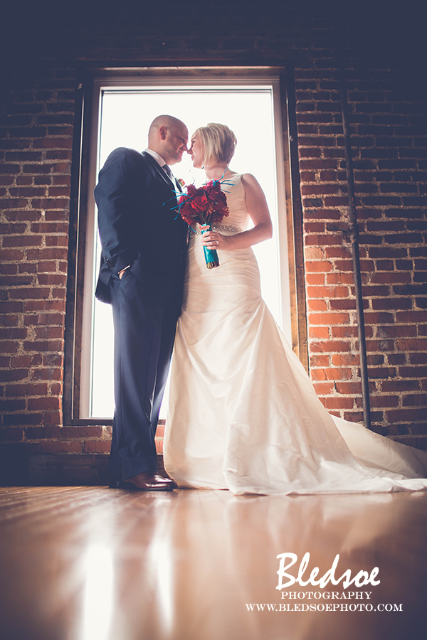 31-nashville-wedding-cannery-one-turquoise-red-navy-bride-groom-backlit-window