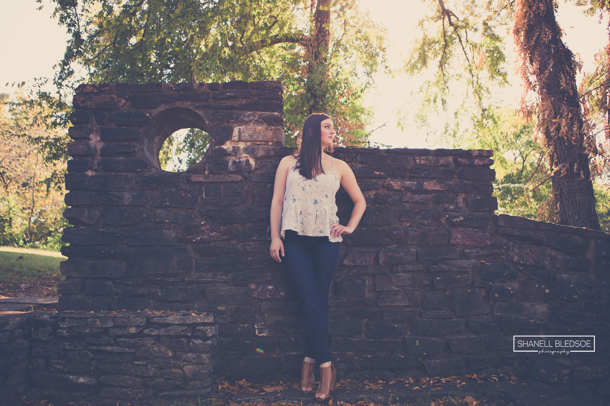 Senior girl posing in front of stone wall in east Tennessee