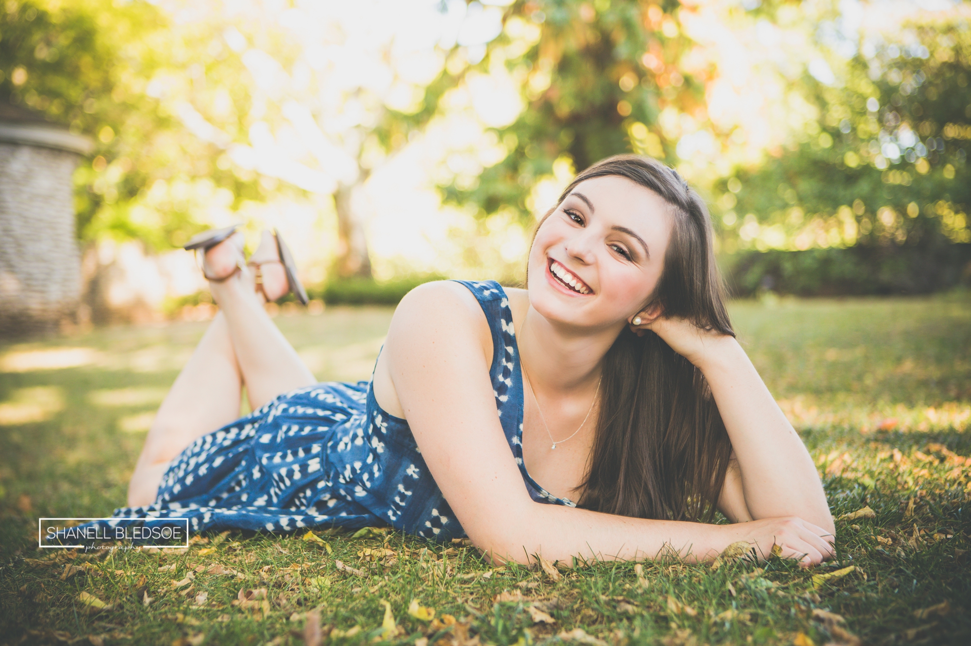 teen girl laying in a garden smiling