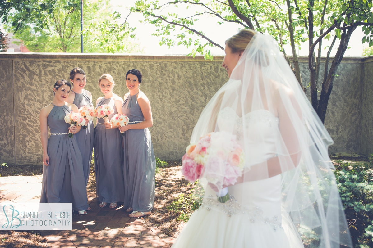 sweet photo of bridesmaids looking at bride.
