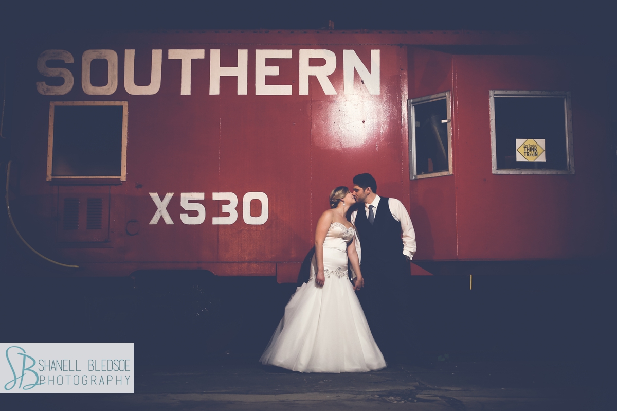 Bride and groom in front of red train car at The Southern Depot in Knoxville, TN