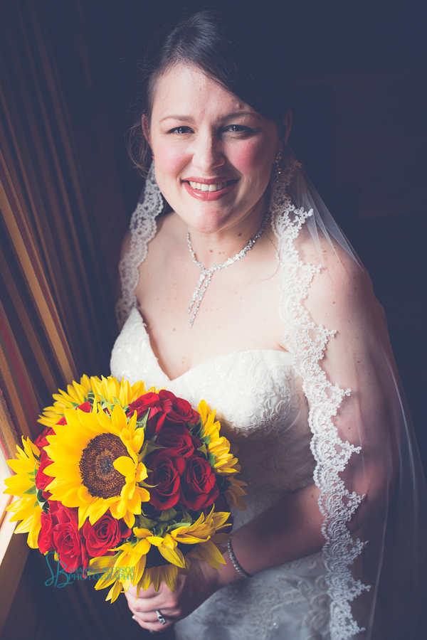 bride in window light, lace veil, sunflower bouquet