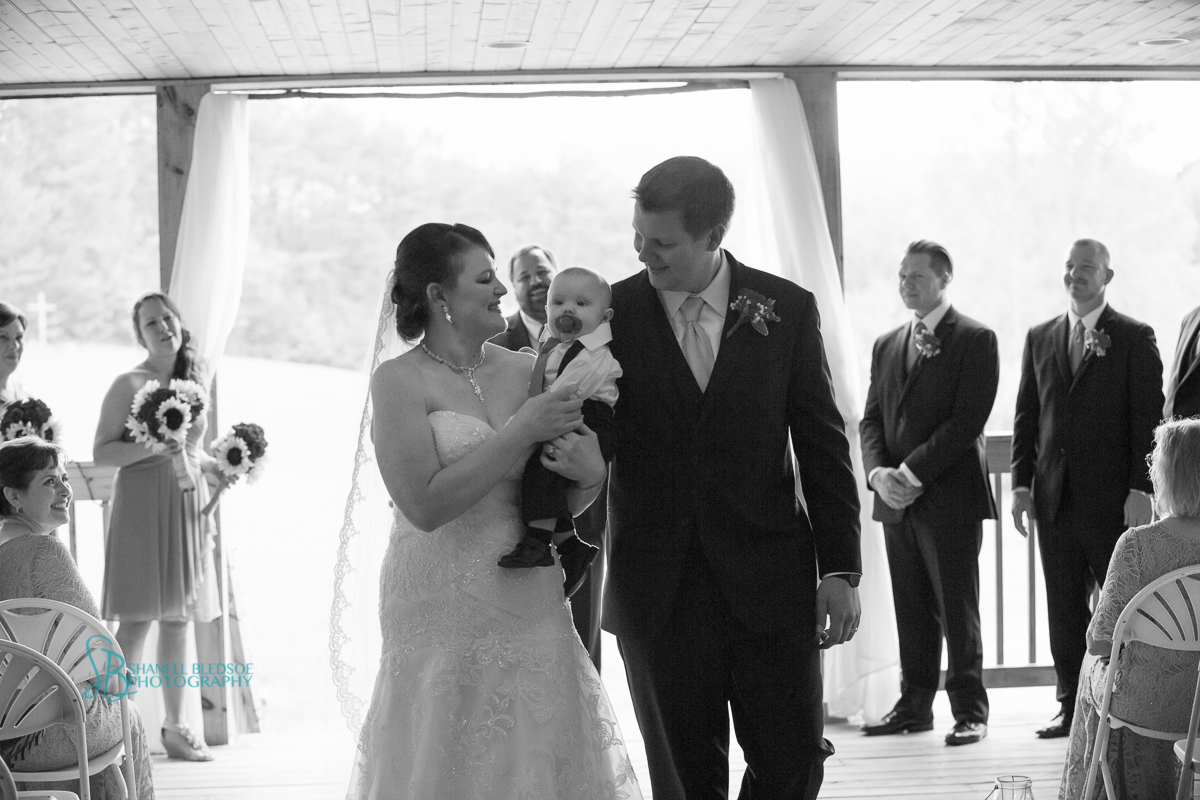 bride groom and their baby at wedding recessional