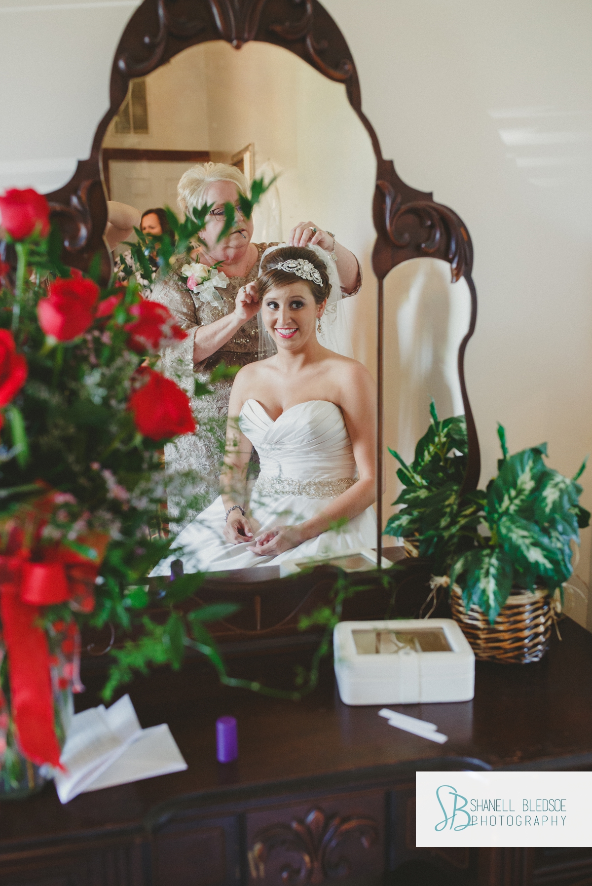 mother putting veil in bride's hair, vintage mirror reflection