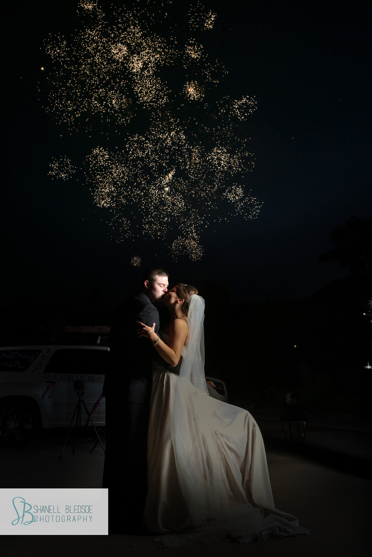 Bride and groom kiss in front of fireworks after wedding reception at the stables in lafollette tn