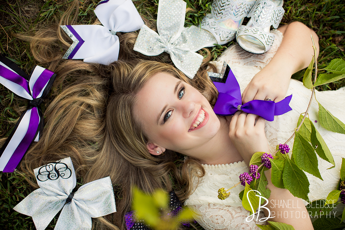 Senior portraits photos with cheerleader hair bows at Ijams Nature Center in Knoxville