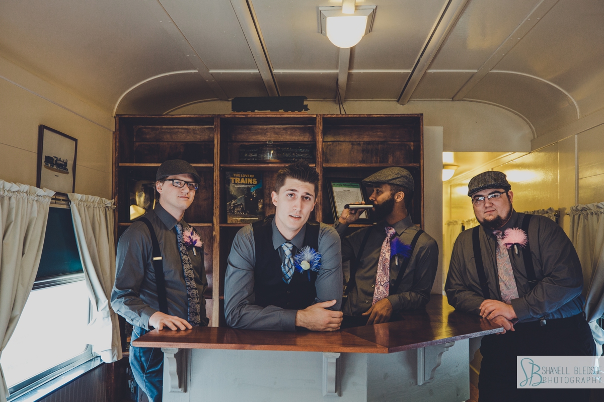 Groom with groomsmen inside of train car at historic southern railway station in knoxville
