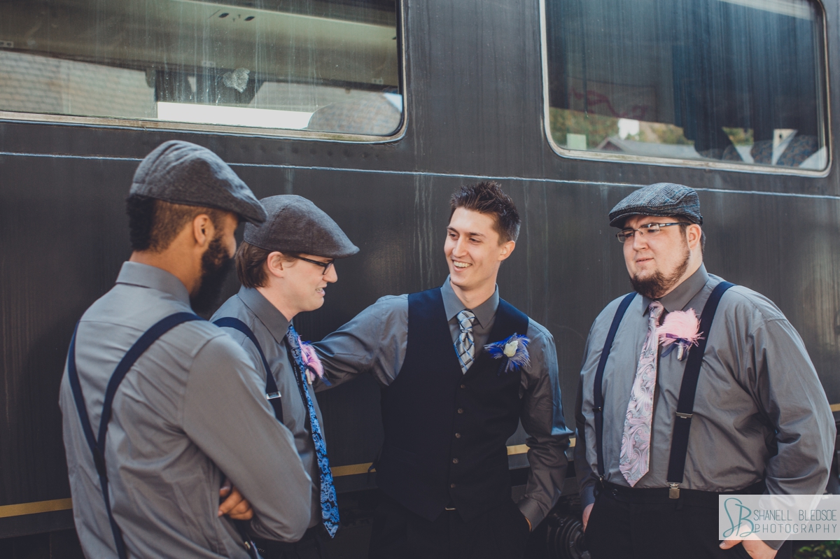 Groomsmen in front of train car at historic southern railway station in knoxville