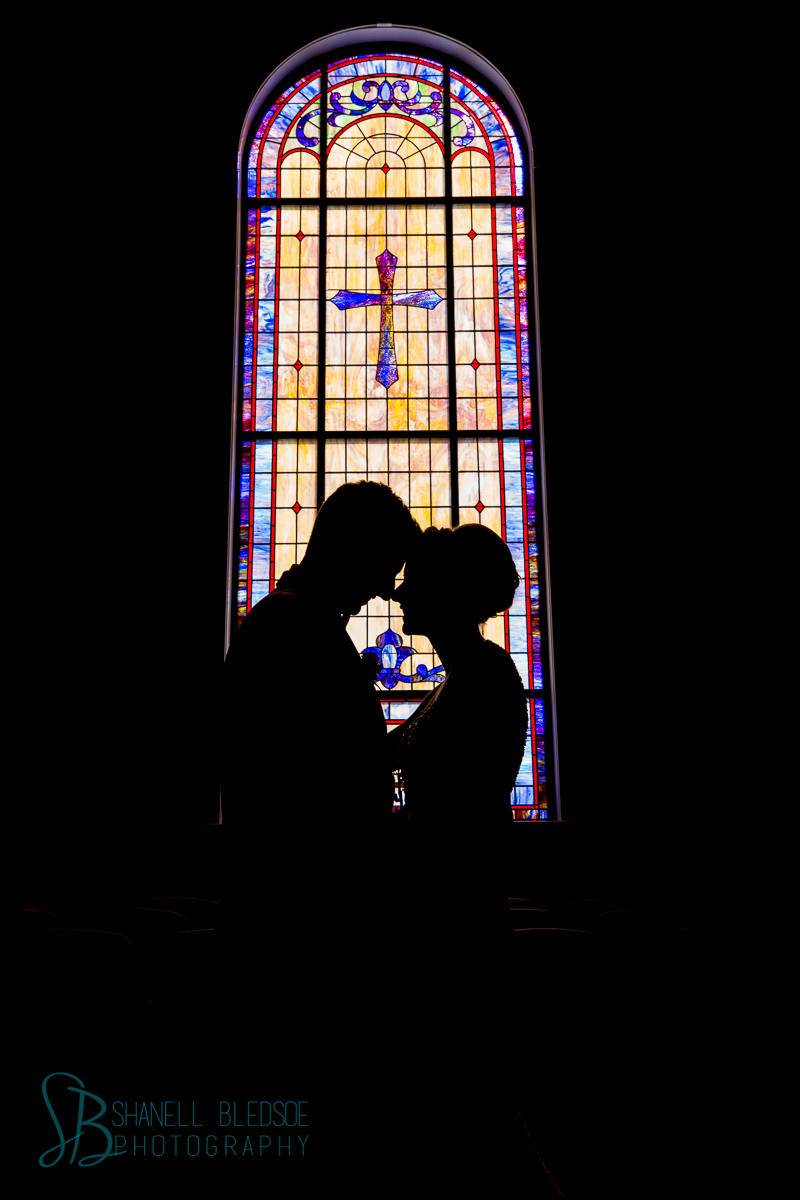 silhouette of bride and groom stained glass window traditional church wedding