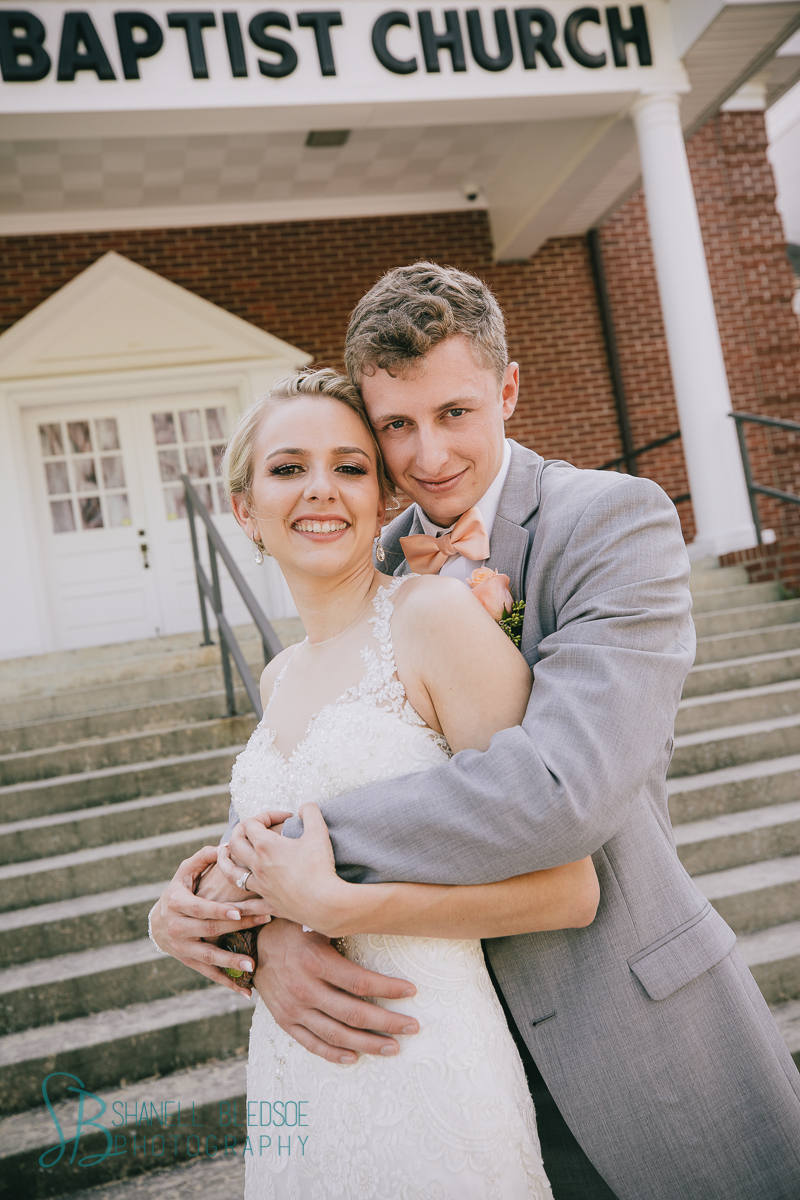 bride and groom in front of southern traditional church wedding 