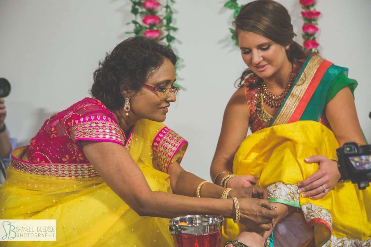 Indian American bride at haldi receiving ankle bracelet gift