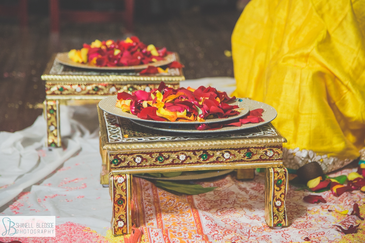 plates of rose petals on stools at indian haldi