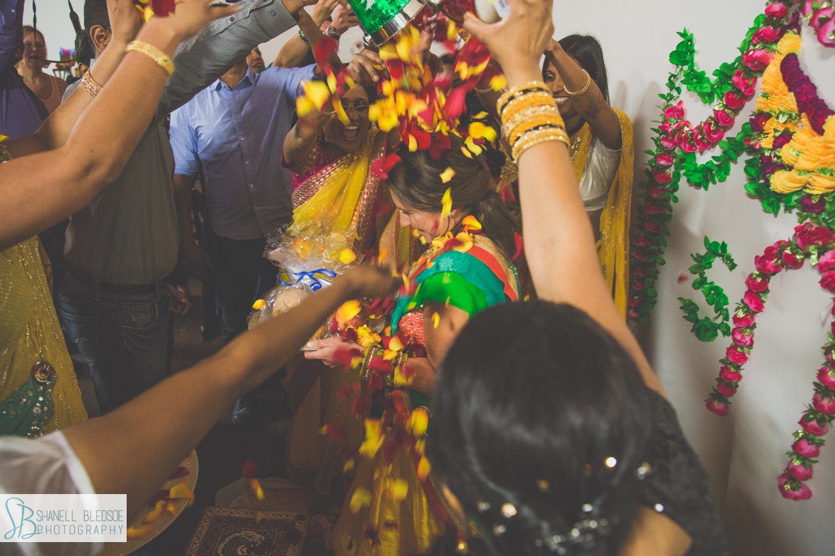 showering bride with rose petals at haldi ceremony pithi