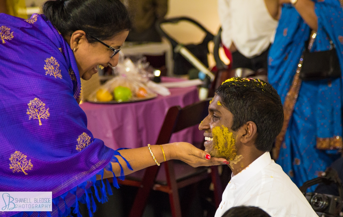 relatives apply turmeric pithi at on groom's face at haldi in Nashville TN