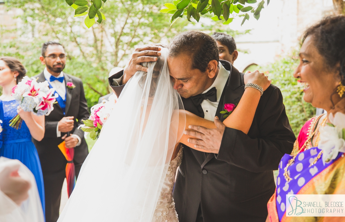 Indian father of the groom embraces American bride