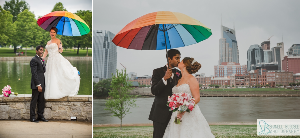 bride and groom under rainbow umbrella in the rain downtown Nashville skyline