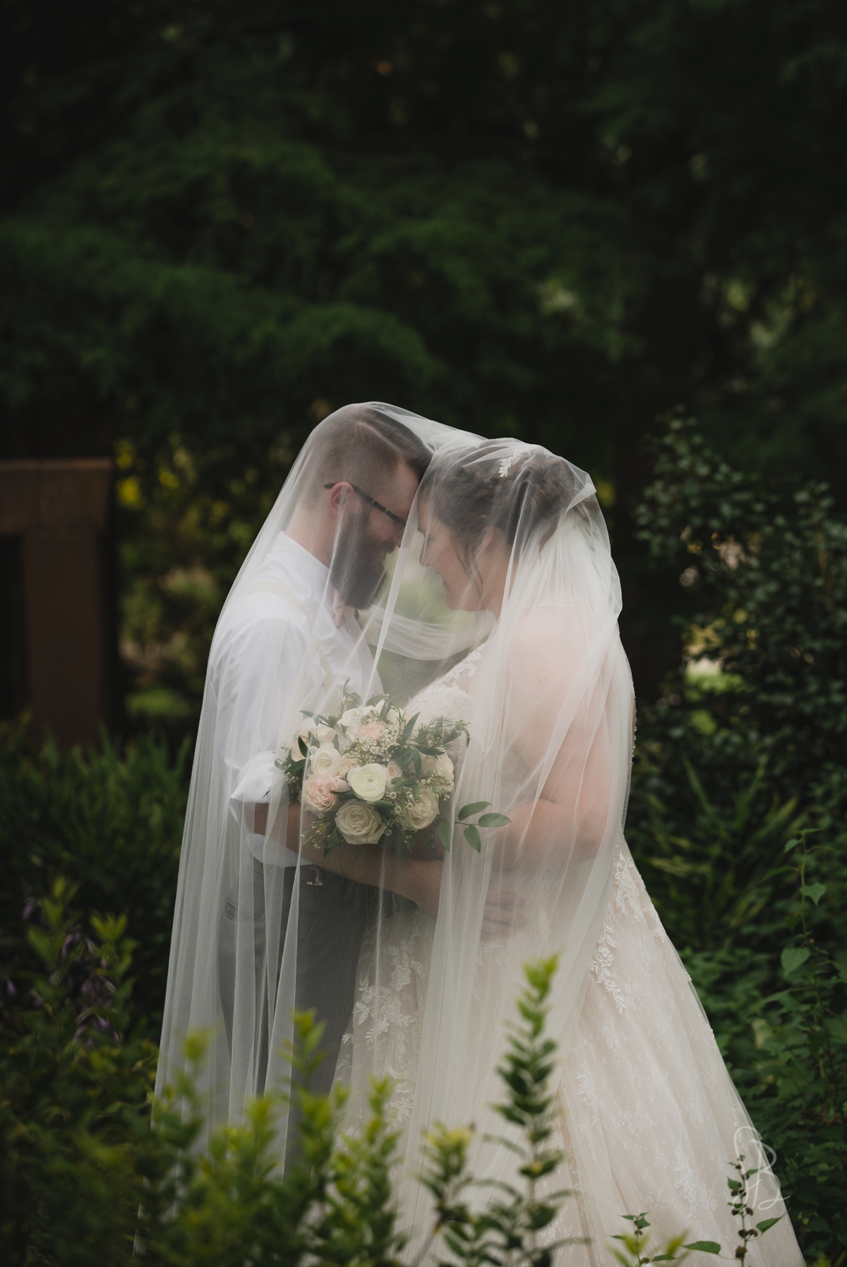 veil over bride and groom at UT Gardens wedding
