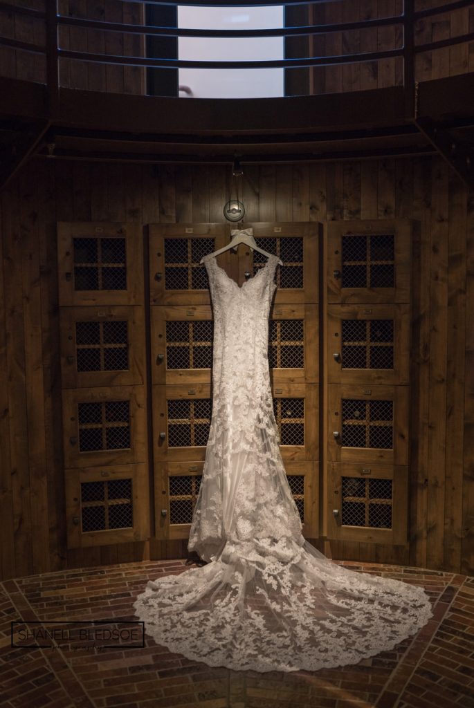 wedding dress hanging in wine tower at Flying horse club