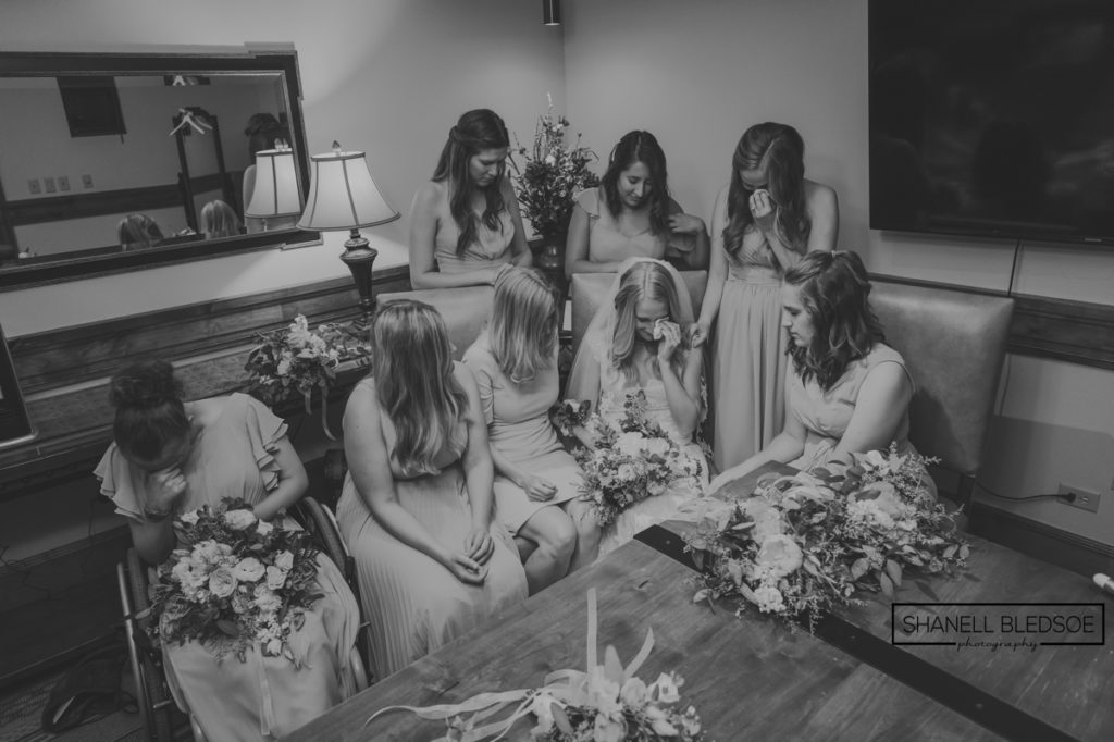 bridesmaids praying over bride in colorado