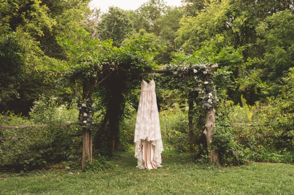wedding dress hanging from arbor