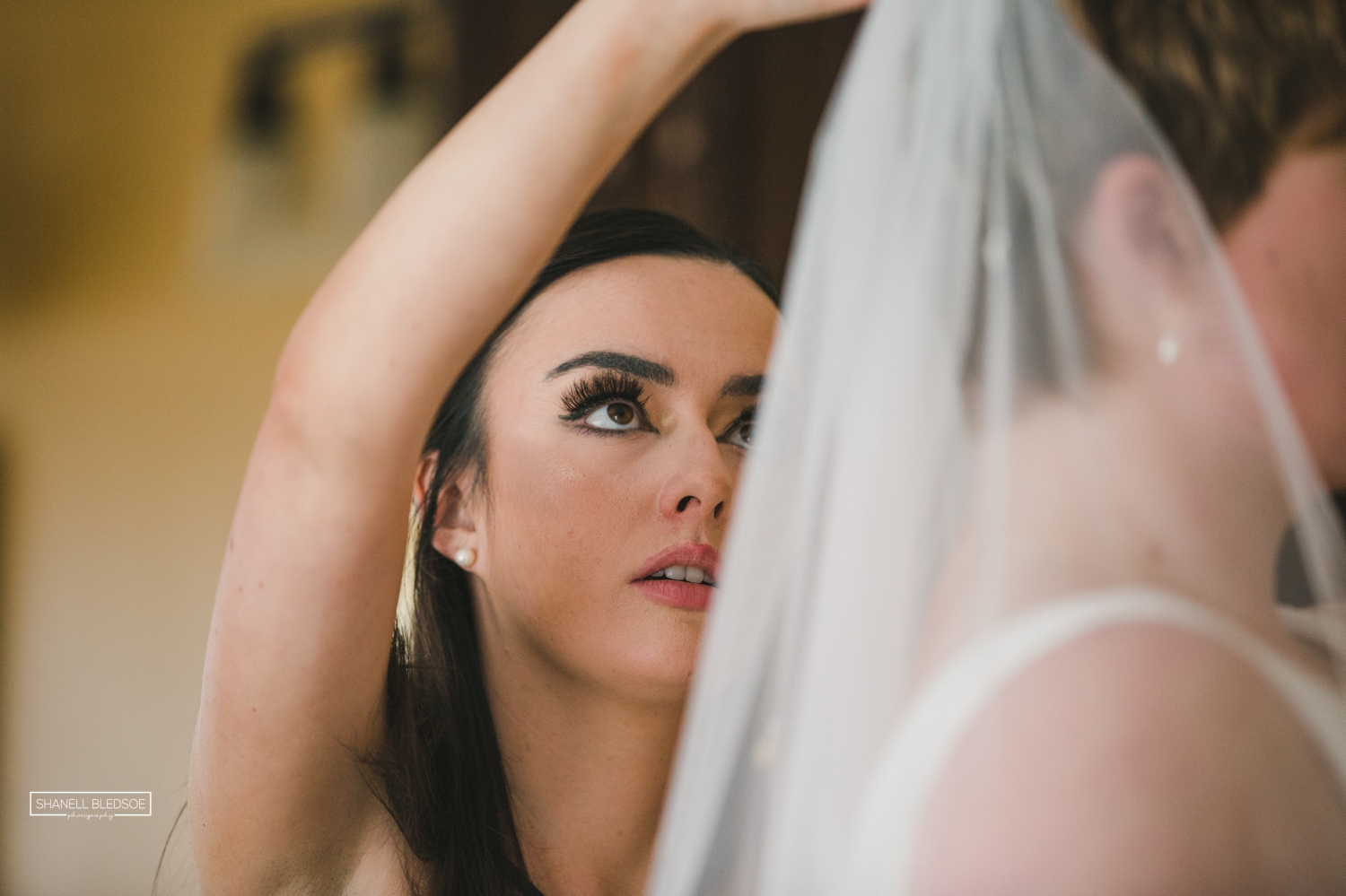 bridesmaid putting veil in bride's hair