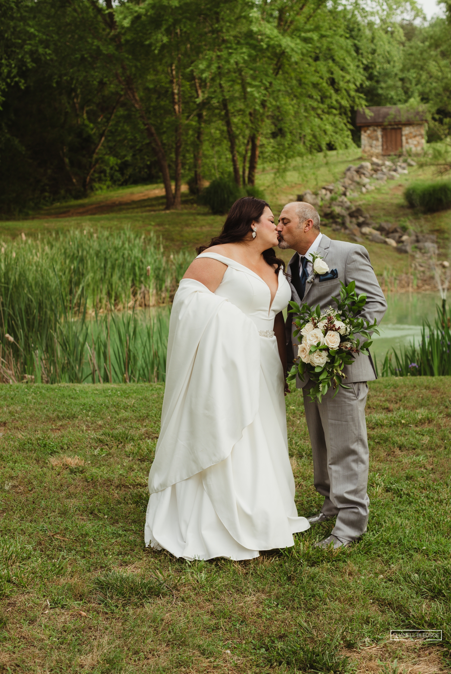 Bride and groom kissing at Willow Pond at Willow Ridge Event Center