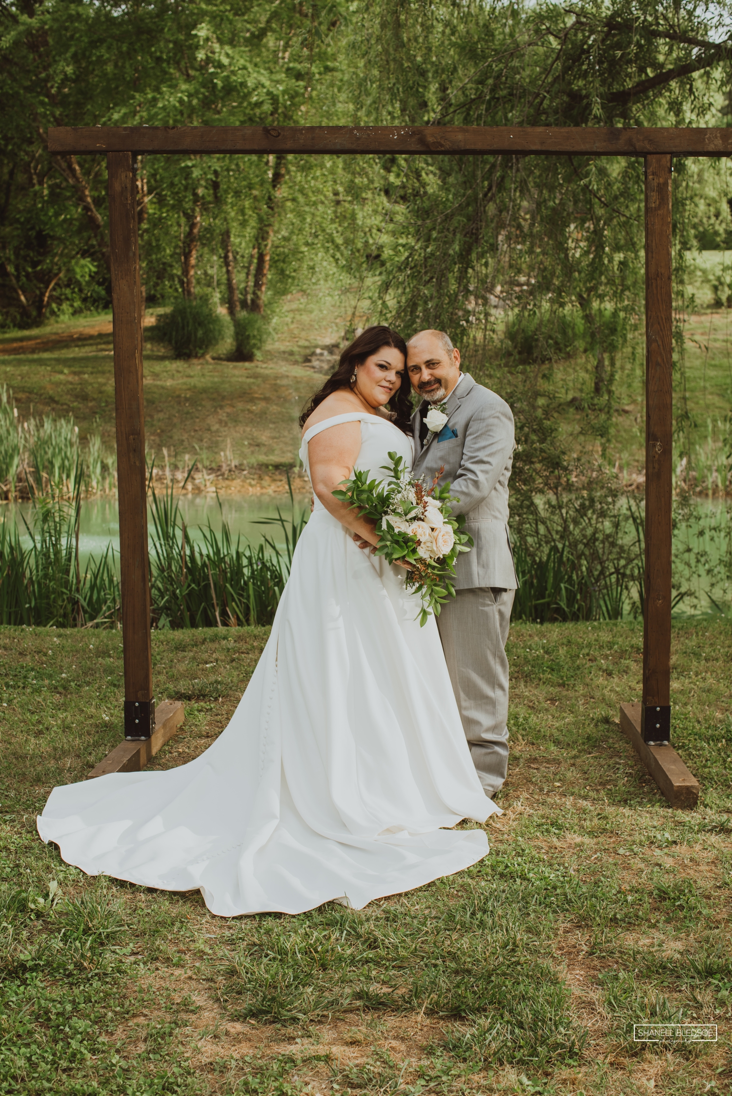 Bride and groom pose at Willow Pond at Willow Ridge Event Center